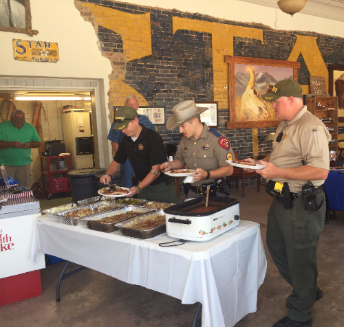 Image of three police officers picking going through a food line.