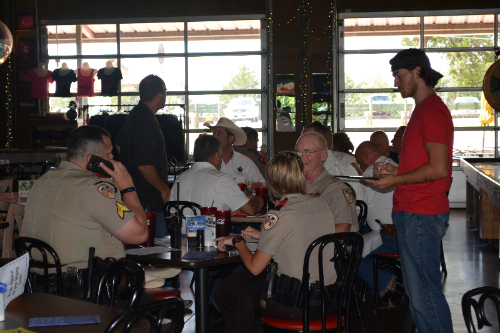 Image of police officers enjoying a meal with a food server taking their order