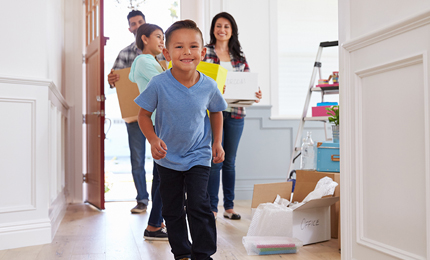 Portrait Of Hispanic Family Moving Into New Home